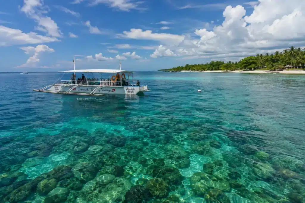 Bateau de plongée au mouillage par mer calme sous un ciel tropical aux Philippines.